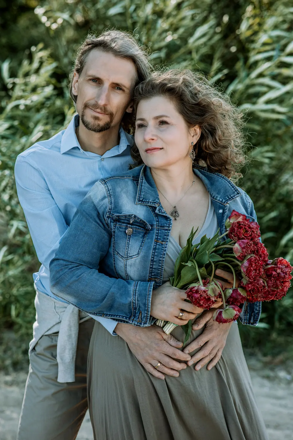 fotografia portretowa warszawa portret sesja rodzinna, małżeństwo z bukietem na tle zieleni