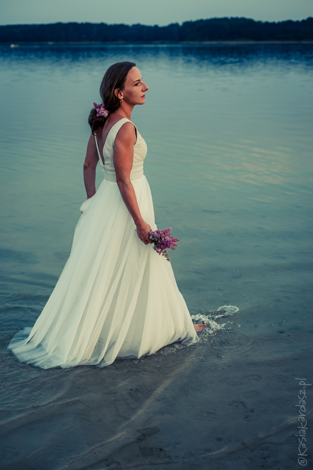 Portret panny młodej w jeziorze o zachodzie słońca, sesja ślubna w plenerze, romantyczna fotografia ślubna.