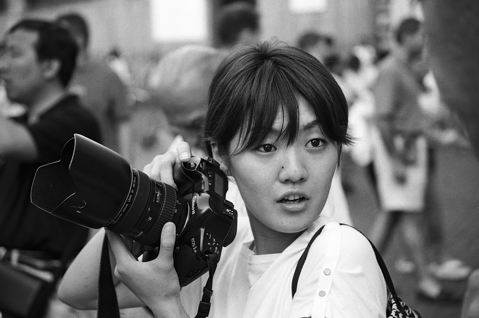 Kobieta profesjonalny fotograf z aparatem analogowym w bazylice św. Piotra w Watykanie. Fotografia czarno-biała. Negatyw