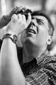 Mężczyzna z aparatem analogowym w bazylice św. Piotra w Watykanie. Fotografia czarno-biała. Negatyw