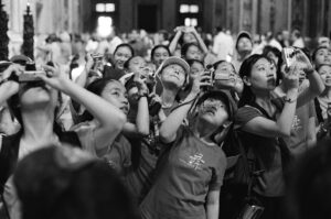 Tłum fotografujących azjatów w bazylice św. Piotra w Watykanie. Fotografia czarno-biała. Negatyw