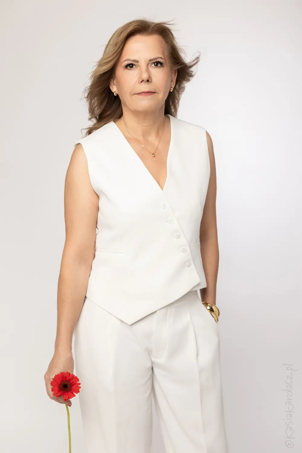 Businesswoman w białej marynarce z kwiatem