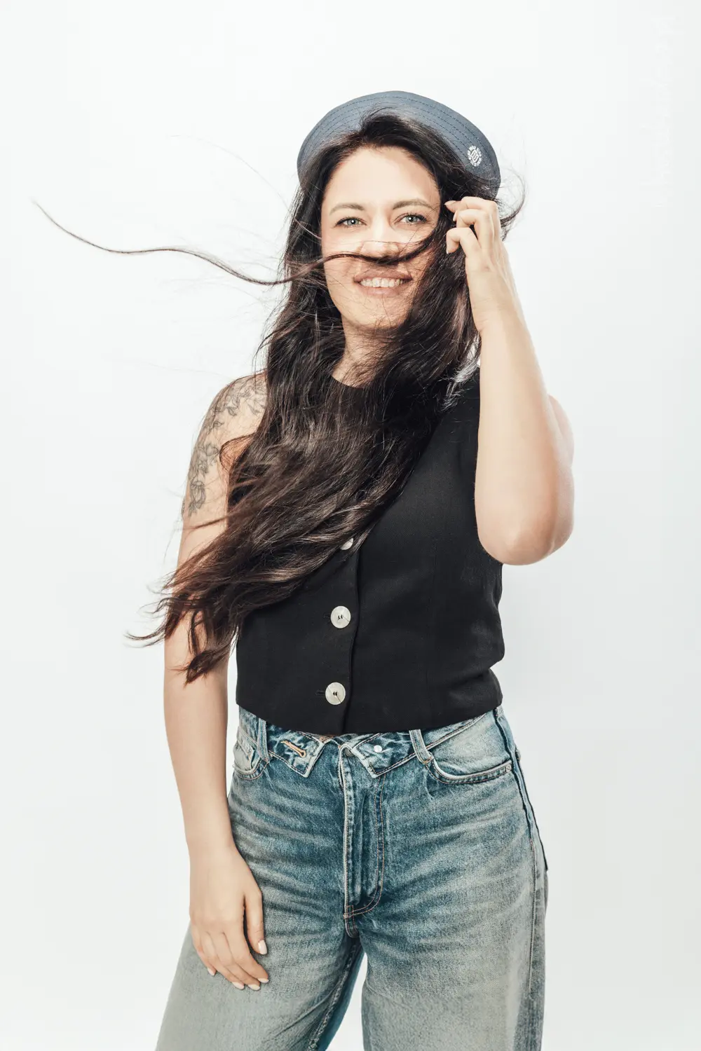 piękna kobieta z długimi ciemnymi rozwianymi włosami na białym tle w studio fotograficznym