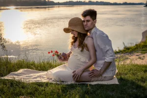Kobieta w ciąży i mężczyzna na kocu nad Wisłą