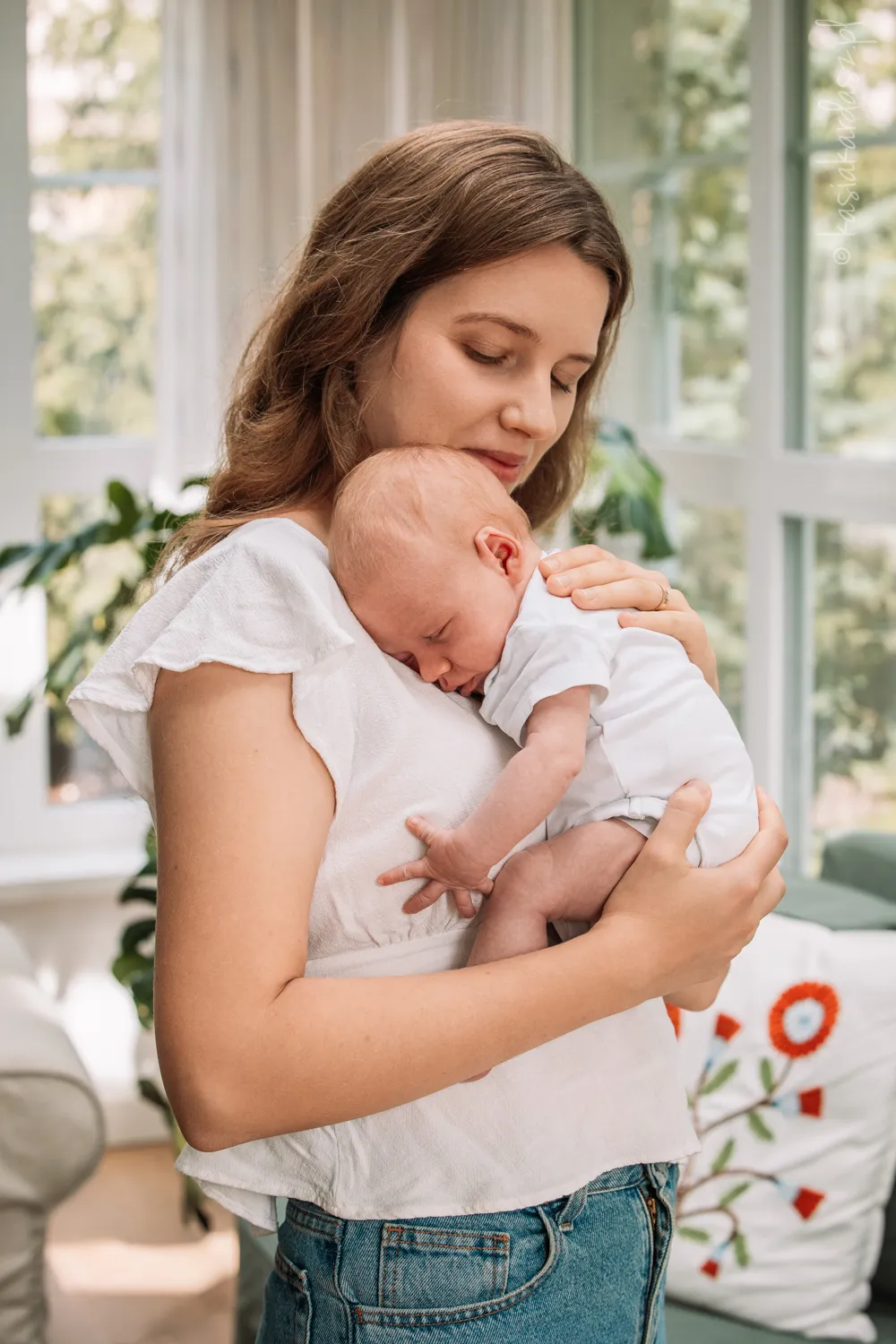 mama tuli noworodka w białej przestrzeni altany